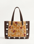 A Valentino Garavani Nellcôte shopping bag with intricate floral embroidery, studded detailing, and palladium-finish hardware. Includes a removable inner pouch and double handles for effortless carrying.